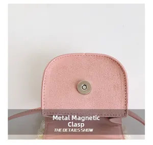 Gros plan du fermoir magnétique en métal sur un mini sac bandoulière rose pour enfant