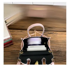 Detail showing the internal storage capacity of the pink polka dot mini crossbody bag