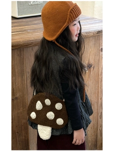 Gros plan d'un sac bandoulière en peluche en forme de champignon avec pois blancs