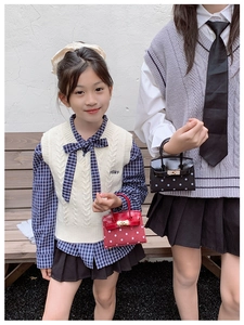 Close-up of stylish polka dot leather mini handbags with metallic buckle for children
