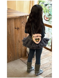 Détail du sac à bandoulière rose en forme de cœur avec nœud et motif à carreaux