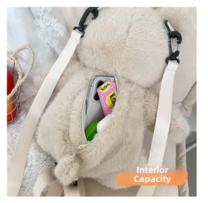 Detail of plush bear backpack interior showing storage for phone and accessories