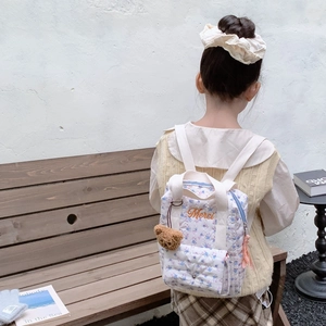 Floral toddler backpack with plush bear and Merci embroidery shown in a lifestyle setting