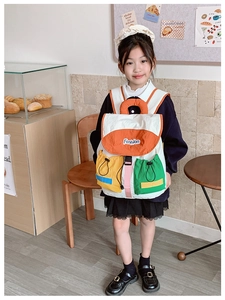 Detail of color-block kids backpack with orange flap and durable cream fabric