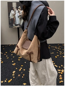 Détail du sac fourre-tout en daim kaki avec des nœuds léopard et une lanière en cuir