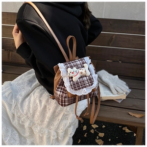 Detail of sweet lace-trimmed plaid toddler backpack with cute plush cat doll decoration