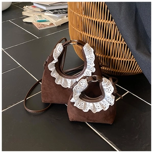 Detail of brown suede handbags with white lace trim and adjustable leather shoulder straps
