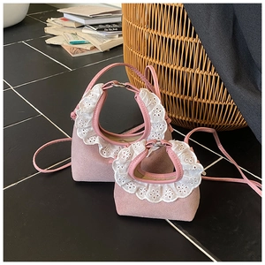Close-up of pink suede kids bag featuring white lace trim and adjustable shoulder straps