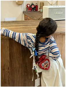 Détail du sac enfant rouge en forme de cœur avec tissu à carreaux et chaîne dorée