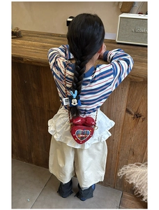 Détail du sac rouge en forme de cœur pour fille avec nœud et chaîne dorée