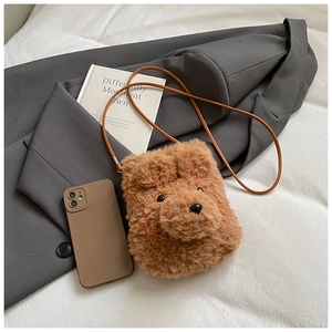 Detailed view of a plush brown teddy bear crossbody bag with a slim leather strap