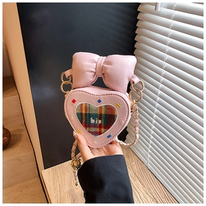 Détail du sac rose en forme de cœur avec grand nœud et motif arc-en-ciel brodé