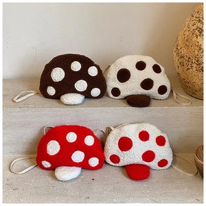 Détail de quatre sacs bandoulière en peluche en forme de champignon pour enfants en polaire