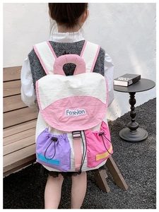 Detail of multi-pocket contrast color school bag for kids with pink handle and flap