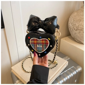 Détail d'un sac à main cœur noir avec broderie écossaise et chaîne dorée