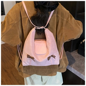 Vue détaillée d'un sac à dos rose en daim avec des nœuds léopard sur un mannequin