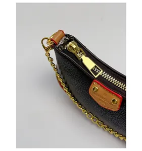 Détail de la fermeture éclair dorée et du cuir marron sur le sac pour enfants