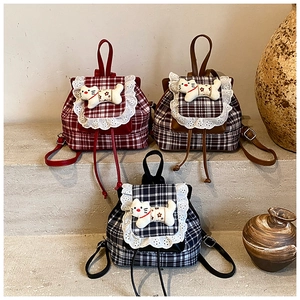 Detailed view of checkered mini backpacks with lace edges and cute cat plush toys
