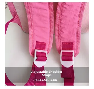 Close-up of pink nylon backpack featuring adjustable shoulder straps and white buckles
