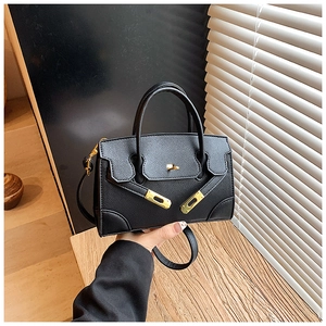 Close-up of black Saffiano leather mini tote bag with gold buckle and adjustable strap