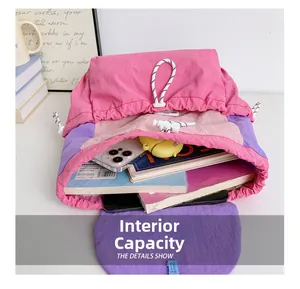 Internal capacity of the color-block nylon backpack showing books and accessories