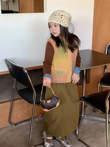 Detailed view of girl's leopard dumpling bag with gold chain and autumn knitwear
