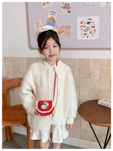 Détail d'un petit sac bandoulière rouge avec dentelle et peluche chat sur un mannequin enfant