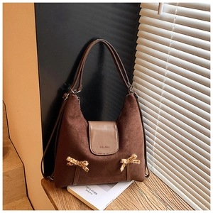 Détail du sac hobo montrant le daim marron avec nœuds léopard et logo imprimé