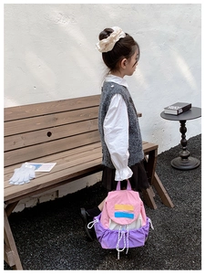 Detail of color-block kids backpack with drawstring closure and waterproof nylon fabric