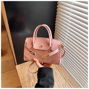 Detail of pink crossbody bag with cross-grain texture and golden metallic lock buckle