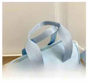 Close-up of light blue cylindrical kids bucket bag featuring comfortable woven handles