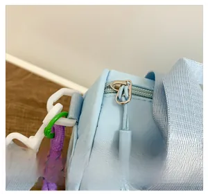 Detail of smooth metal zipper and colorful woven rope on sky blue kids bucket bag