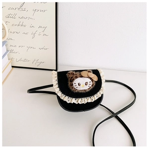 Détail d'un sac bandoulière noir mat pour enfant avec dentelle et écusson en peluche