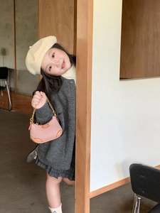 Close-up of pink and orange mini shoulder bag with gold chain strap for kids