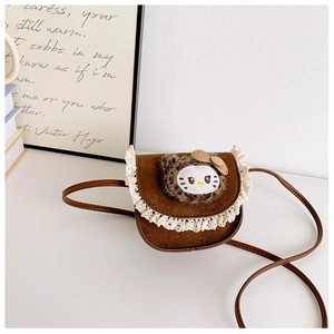 Détail du mini sac en daim marron avec bordure en dentelle et patch chat léopard