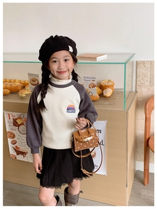Close-up of mini polka dot kids handbag with leather strap in a warm bakery setting
