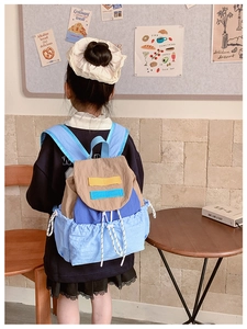 Detail view of colorful patchwork kids backpack with drawstring side pocket and flap cover