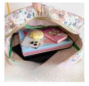 Quilted backpack interior with cartoon bear pattern and pink checkered lining showing high capacity