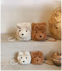 Detailed view of plush teddy bear crossbody bags in white and caramel faux fur texture