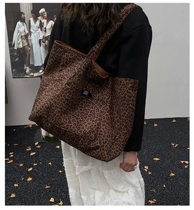 Détail du sac cabas léopard avec une poche avant pratique et une étiquette tissée noire