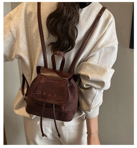 Detail view of the cute cat face embroidery and 3D ears on a brown children backpack