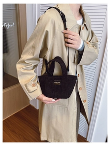 Détail d'un mini sac seau en velours côtelé marron foncé avec bandoulière amovible