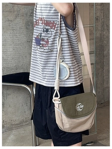 Détail du sac bandoulière en toile kaki avec rabat vert olive et pochette à monnaie bleue