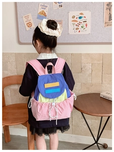 Detail of colorful patchwork kids backpack featuring drawstring closure and nylon fabric