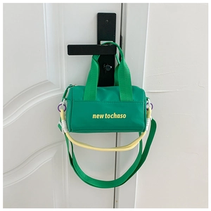 Close-up of green nylon bucket bag with yellow 'new tochaso' lettering and rope detail