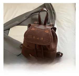 Detail view of brown cat-themed backpack featuring embroidered whiskers and ears
