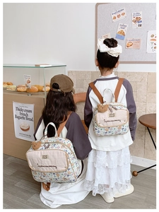 Detail of floral canvas kids backpack with plush bear pendant and adjustable straps