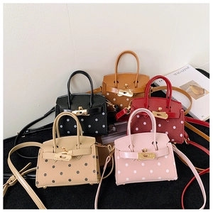 Detailed macro view of mini polka dot children's bags with elegant metal twist locks