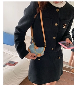 Détail du mini sac bandoulière en jean avec bordure en cuir marron et chaîne dorée