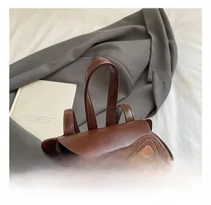 Detail shot of a brown cat-themed children backpack featuring premium leather and suede texture